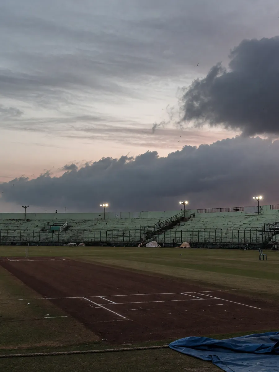 Editorial photograph of an Indian cricket batsman facing a delivery on a green pitch